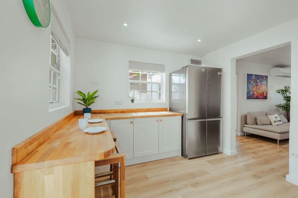 Kitchen breakfast bar with extra seating and a full-size refrigerator—convenient for quick meals, morning coffee, or keeping drinks and groceries stocked during your stay.