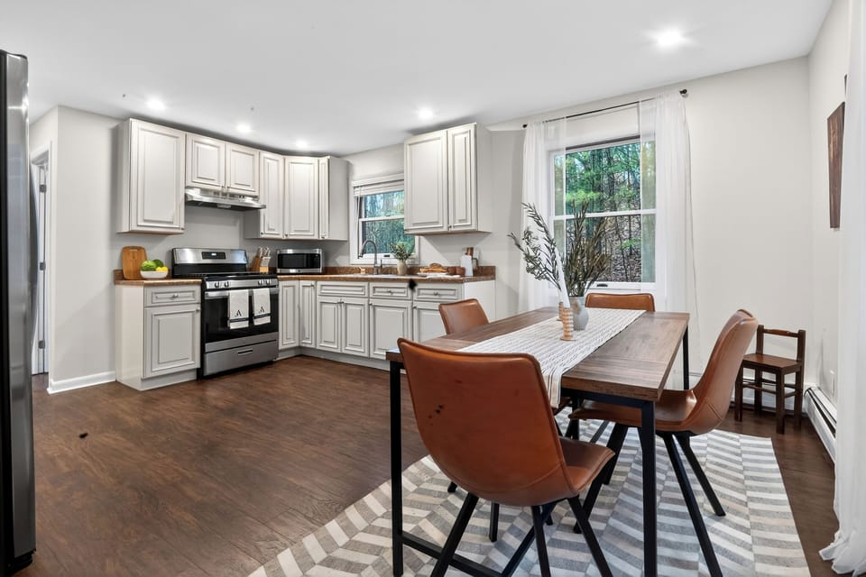 Cozy modern dining area with leather seating, natural light, and a seamless flow into the kitchen.