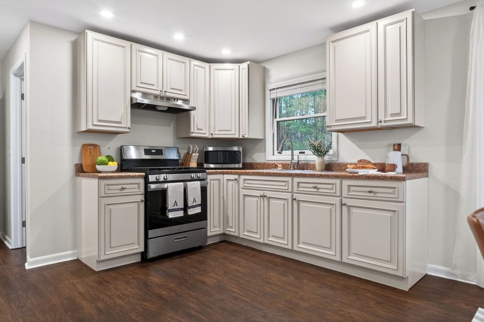 Bright modern kitchen with stainless steel appliances, warm cabinetry, and a welcoming island set for cooking and conversation.