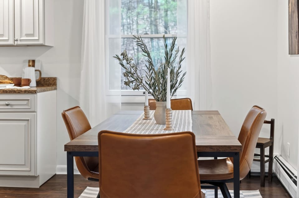 Cozy modern dining area with leather seating, natural light, and a seamless flow into the kitchen. (The Summit)