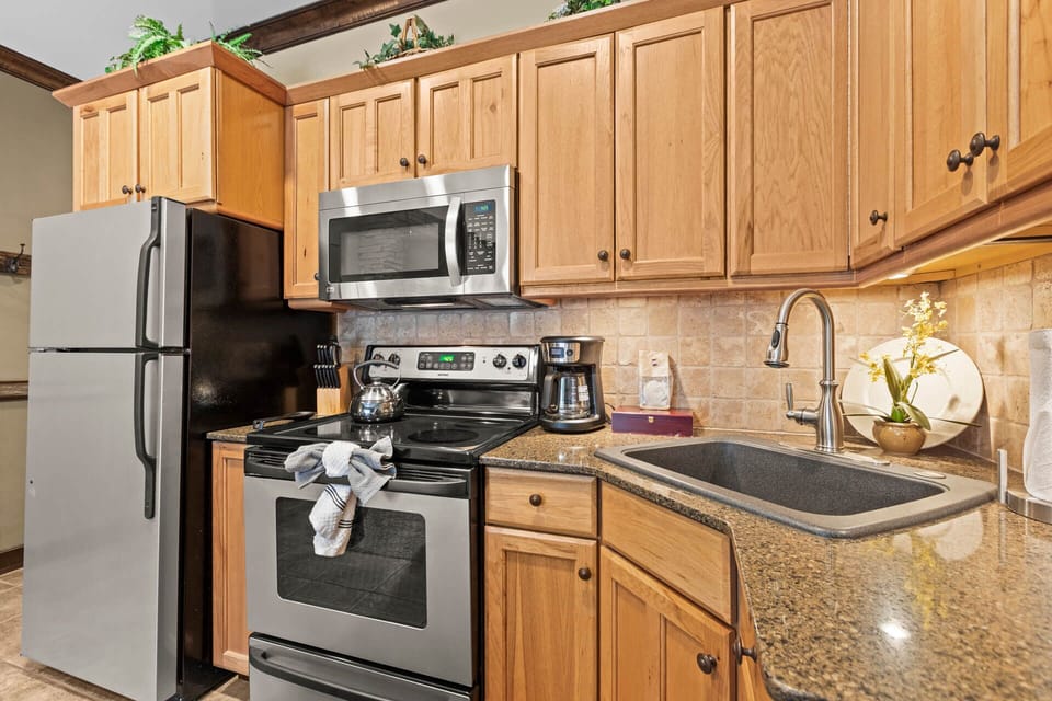 Prepare your favorite meals in this inviting kitchen with modern stainless-steel appliances, ample cabinet space, and elegant granite countertops—everything you need for a comfortable stay.