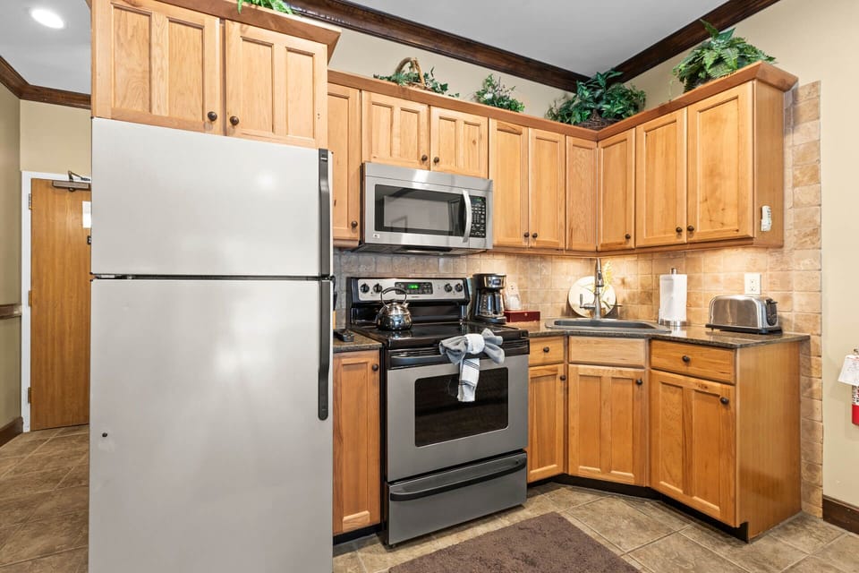 Your fully equipped kitchen features warm oak cabinetry, stainless appliances, and everything you need to prepare meals during your stay—including a coffee maker to start your mornings right.