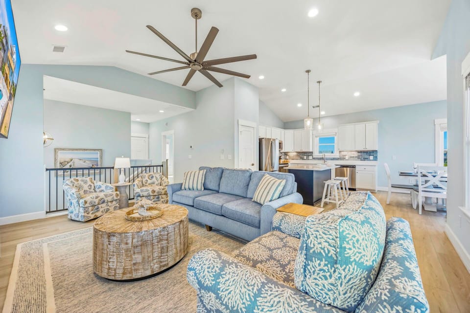 Unwind in your open-concept living space, where coastal-inspired blues meet modern comfort. Sink into plush seating, enjoy the soaring ceilings, and savor the seamless flow into a chef-ready kitchen perfect for gathering.
