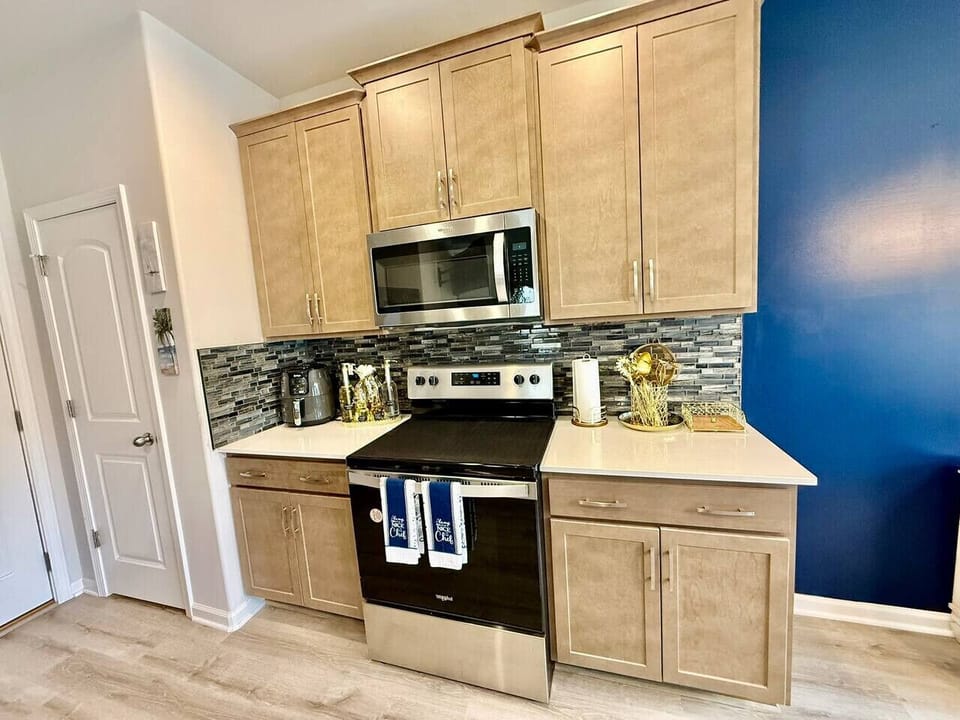 Stylish kitchen with modern stove, wooden cabinets, and elegant backsplash.
