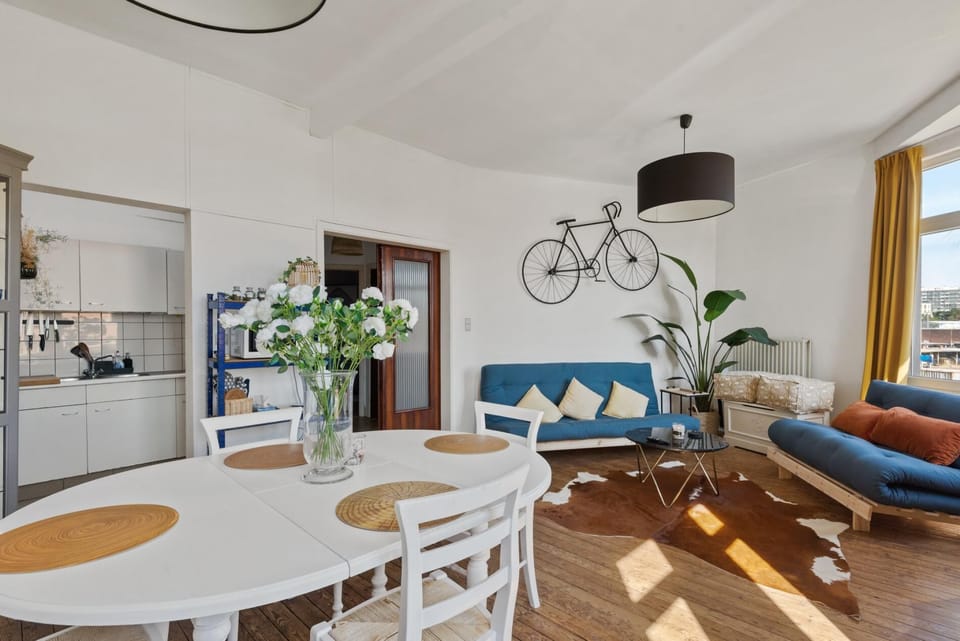 Spacious open plan living and dining area with natural light from large windows. Enjoy relaxed seating, a bright dining table for shared meals, and easy access to the kitchen, creating a comfortable space to unwind and gather.