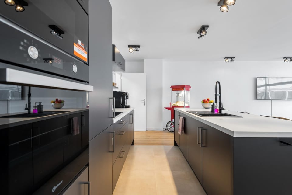 Modern kitchen with a spacious island, built in oven, and sleek cabinetry offering plenty of workspace. The open layout connects easily to the living area, making it convenient to cook, prepare drinks, and gather together.