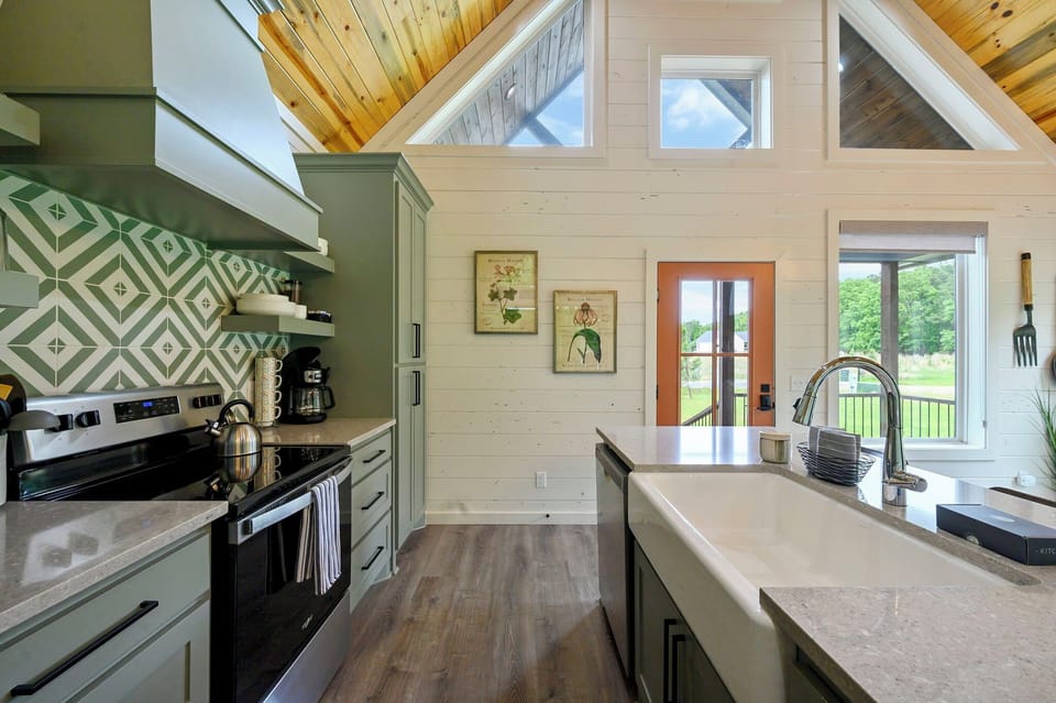 Your fully equipped kitchen awaits with stunning wood ceilings, stylish sage cabinets, and peaceful views through French doors.