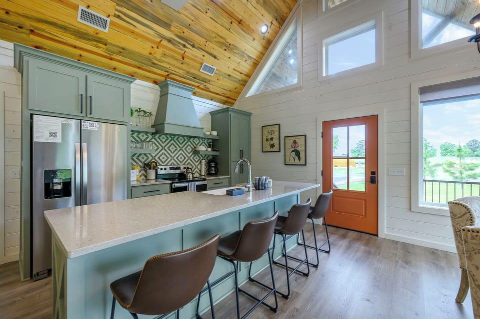 Your stunning open kitchen features soaring wood ceilings, sage cabinetry, and spacious island seating where you'll love gathering for meals.