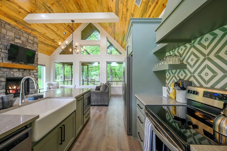 Your gourmet kitchen flows seamlessly into the living space, where soaring cathedral ceilings and windows frame forest views.