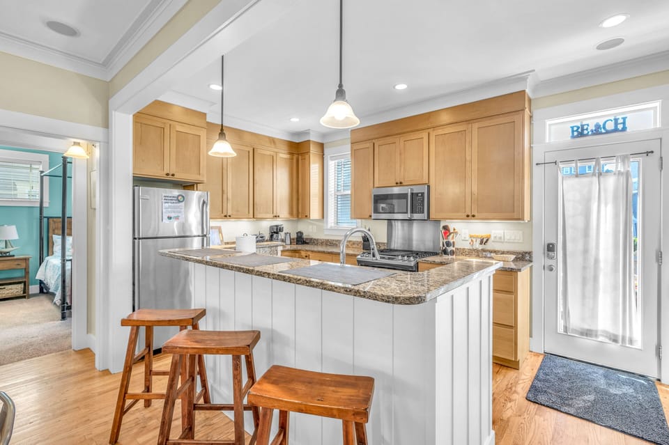 Your fully equipped kitchen features granite countertops, stainless steel appliances, and a breakfast bar where you can enjoy morning coffee.