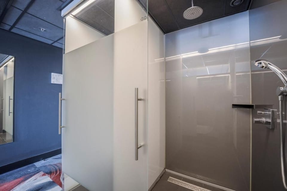 Refresh under a spacious rain shower with modern glass surround