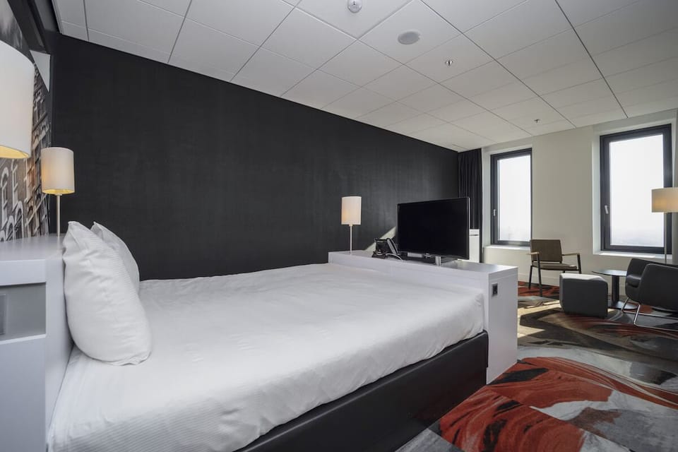 Sink into a plush bed beside bright city windows.