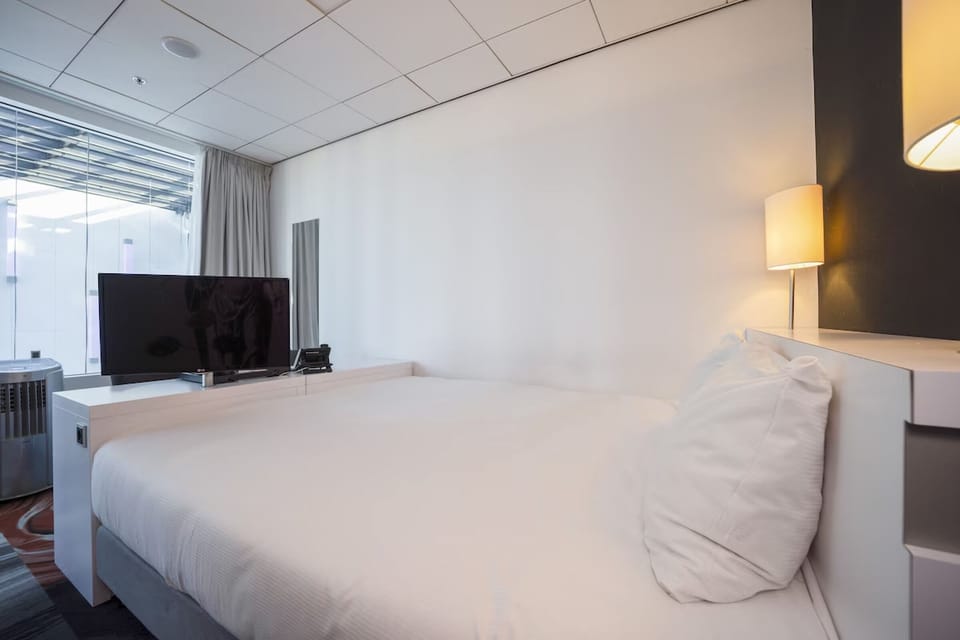 Drift off in crisp linens beside soft bedside lighting.