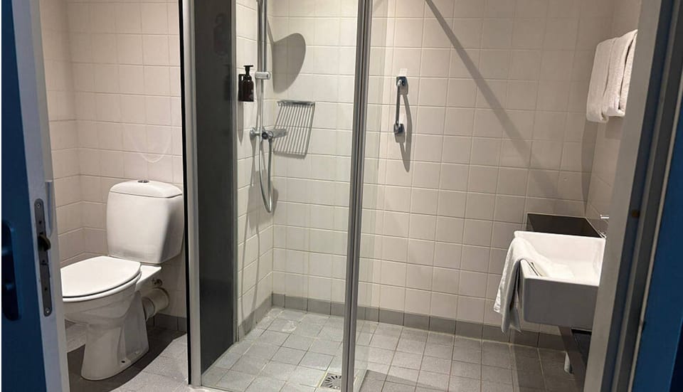 Refresh under a clean, spacious shower with bright towels.