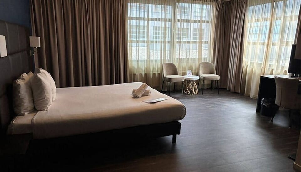 Unwind in a spacious bedroom with soft light and seating