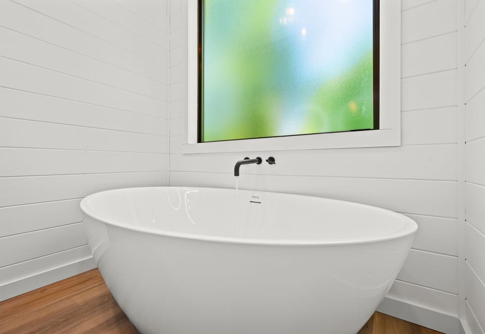 The freestanding soaking tub creates a spa-like experience where you can unwind after hiking trails, lake days, or evenings around the fire pit.