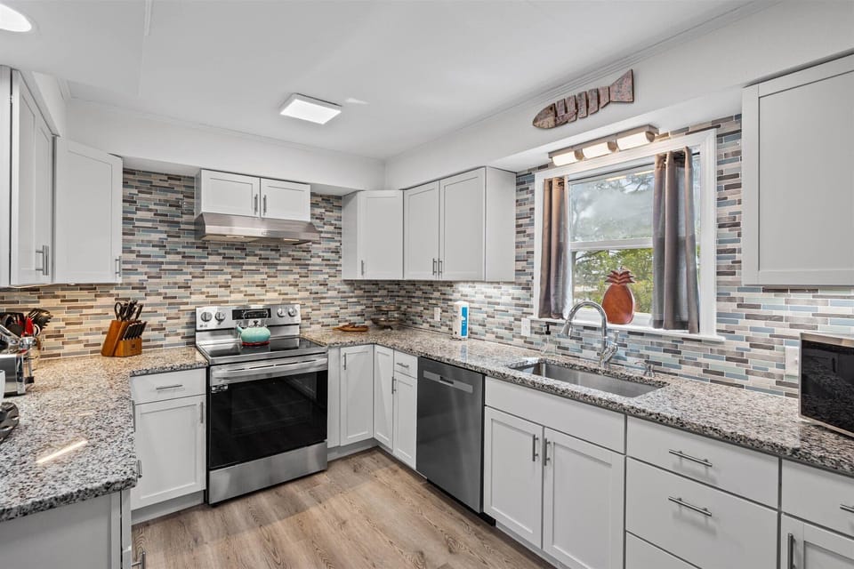 Your spacious kitchen features granite countertops, modern appliances, and stylish tile backsplash - perfect for preparing your favorite meals.