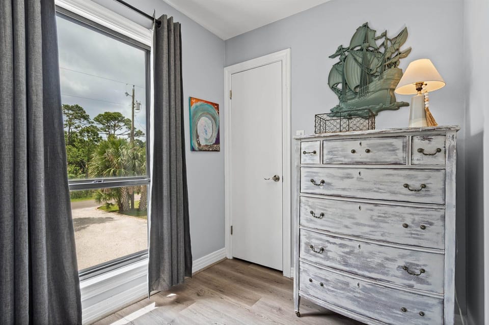 Your coastal retreat bedroom features charming nautical touches and peaceful views of palm trees through your private window.