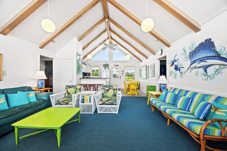 Bright, beachy living space with vaulted ceilings and playful coastal decor invites you to unwind after a day of adventure.