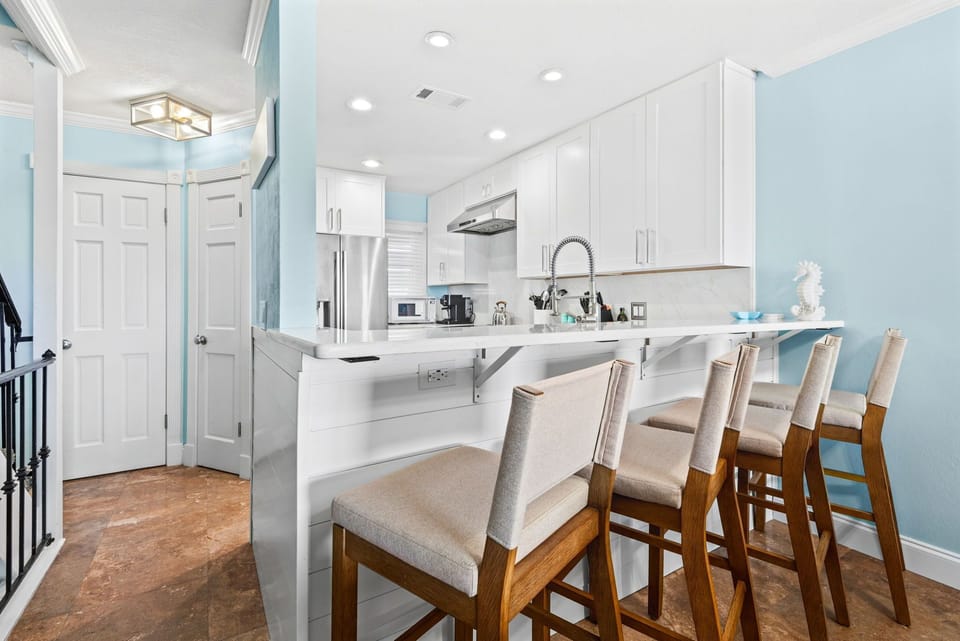 The modern kitchen features a breakfast bar perfect for morning coffee or casual meals.