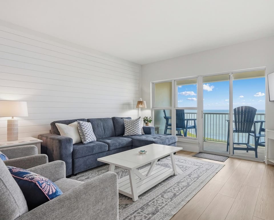 Living room with sectional and bay views