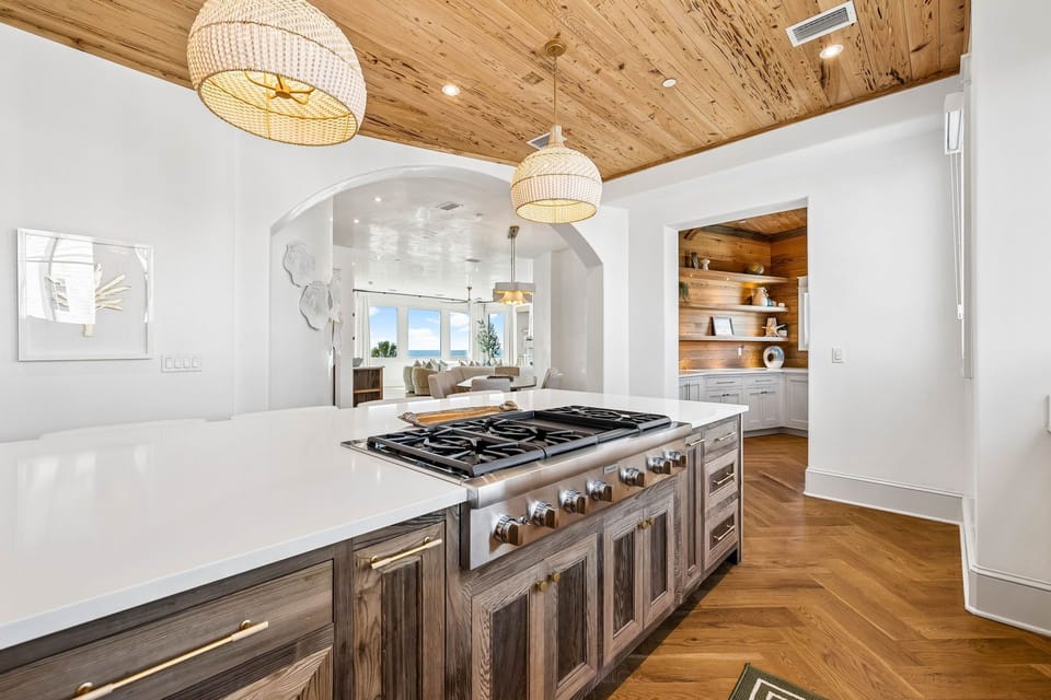 Step into a chef's dream kitchen where rustic warmth meets modern elegance. Cook gourmet meals on the professional-grade gas range while natural light flows through open archways, connecting you to inviting living spaces beyond.