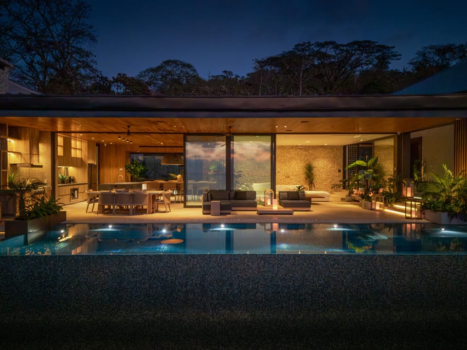 Evening view of Villa Kuji Biri’s open-air living spaces and infinity pool in Santa Teresa, Costa Rica.