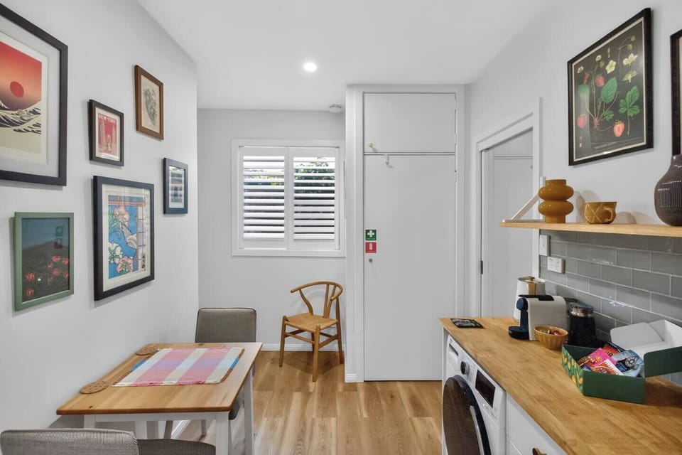 Dine beneath a curated gallery wall in the dining nook, where a table for two offers a cosy setting for quick bites or planning a day.