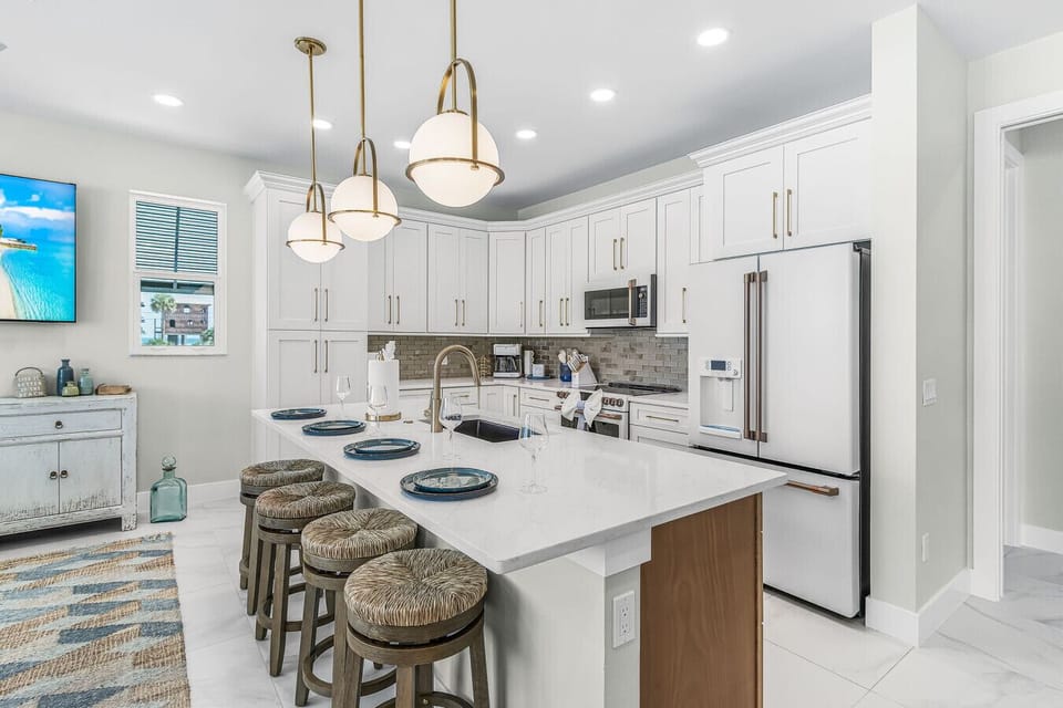 A chef`s dream! This stunning, bright kitchen boasts top-of-the-line appliances, beautiful gold accents, custom cabinetry, and all the cookware you need to feel right at home.