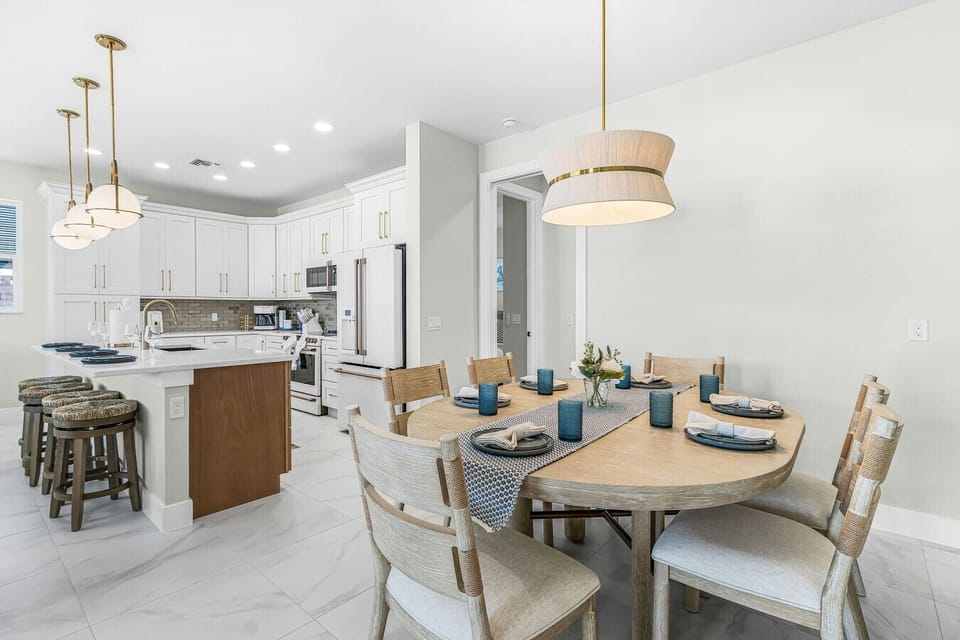 Gather around the beautiful dining table for home-cooked meals. The adjacent chef`s kitchen features stainless steel appliances, stunning gold accents, and a massive island with barstool seating.