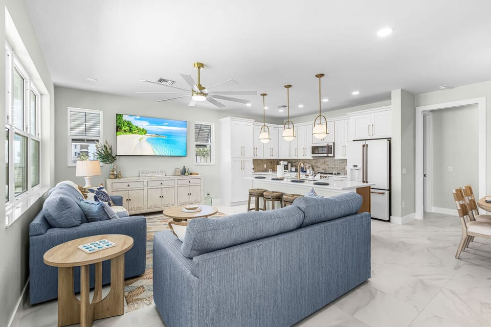 Bright, airy, and beautifully designed. This spacious living room flows seamlessly into a fully equipped gourmet kitchen, complete with stainless steel appliances and barstool seating.