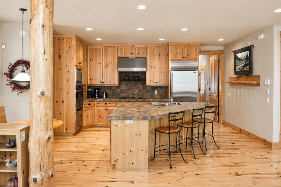 Rustic wood beams and warm knotty pine create your mountain retreat kitchen, perfect for family meals and morning coffee.
