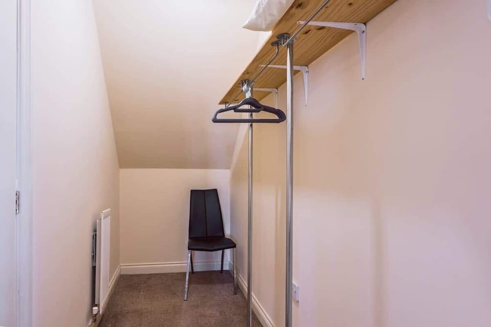 Simple wardrobe space with hanging rail and organized storage area.
