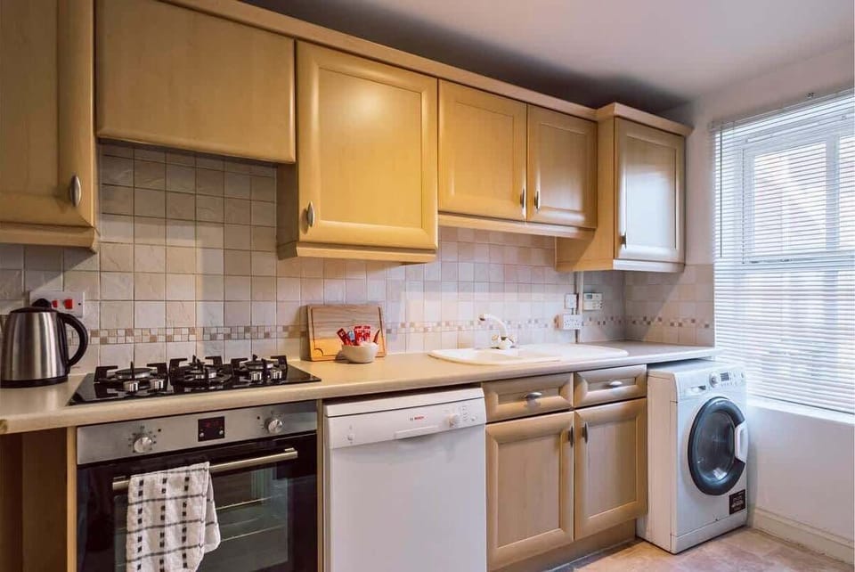 Compact kitchen featuring wooden cabinets and modern appliances for convenience.
