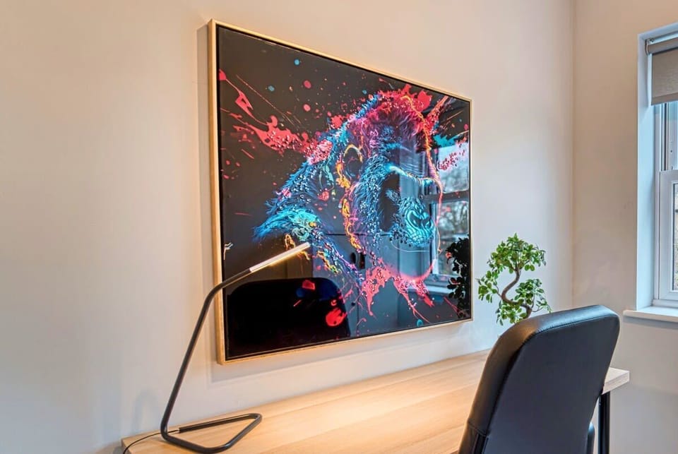 Contemporary desk setup vibrant abstract artwork lamp clean workspace style
