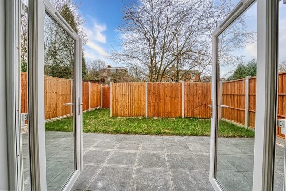 Private backyard with fenced lawn, patio area, and relaxation space.
