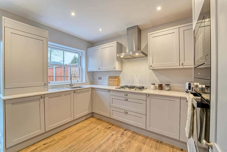 Spacious kitchen featuring sleek cabinets, appliances, and warm wooden flooring.