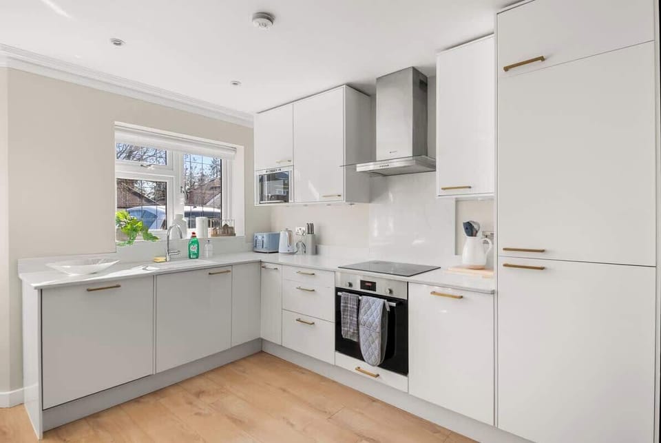 Clean white kitchen with integrated appliances, ample storage, bright finishes