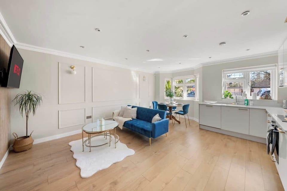 Spacious living area with blue sofa, natural light, open layout