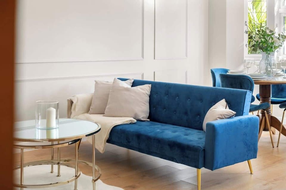 Elegant blue velvet sofa with gold accents and soft cushions