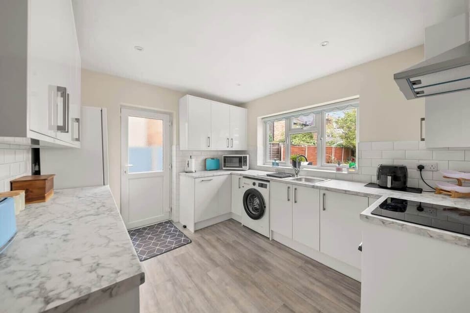 Modern kitchen with white cabinets, appliances, and plenty of space