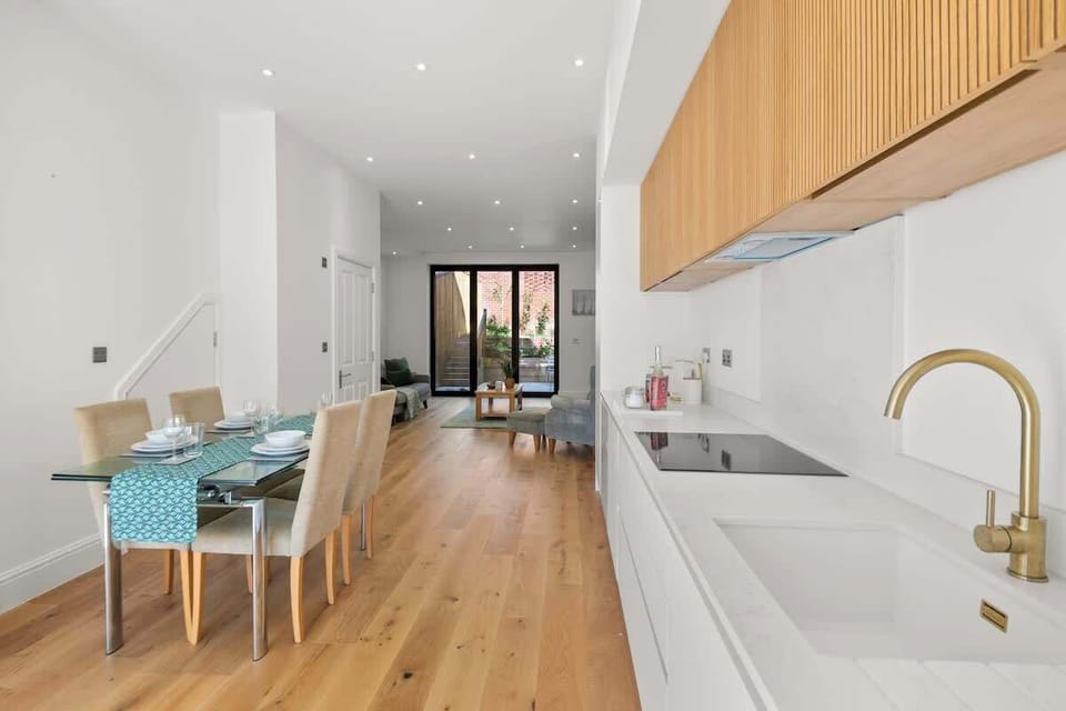 Extended kitchen and dining corridor with wood floors, modern cabinetry