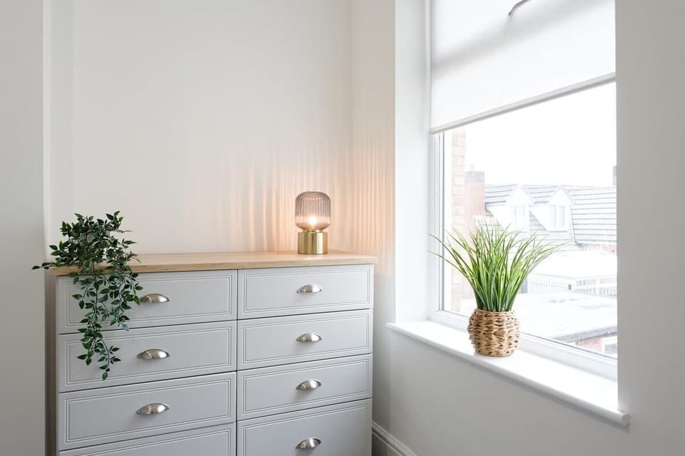 Elegant dresser corner with greenery and warm ambient lighting accents
