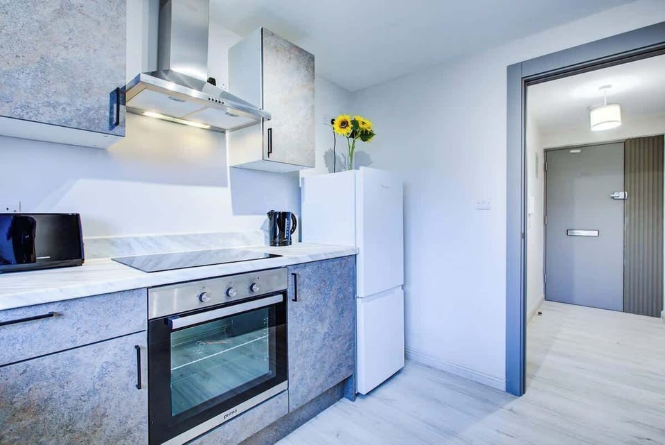 Clean kitchen design with oven, cabinets, and bright decorative sunflower
