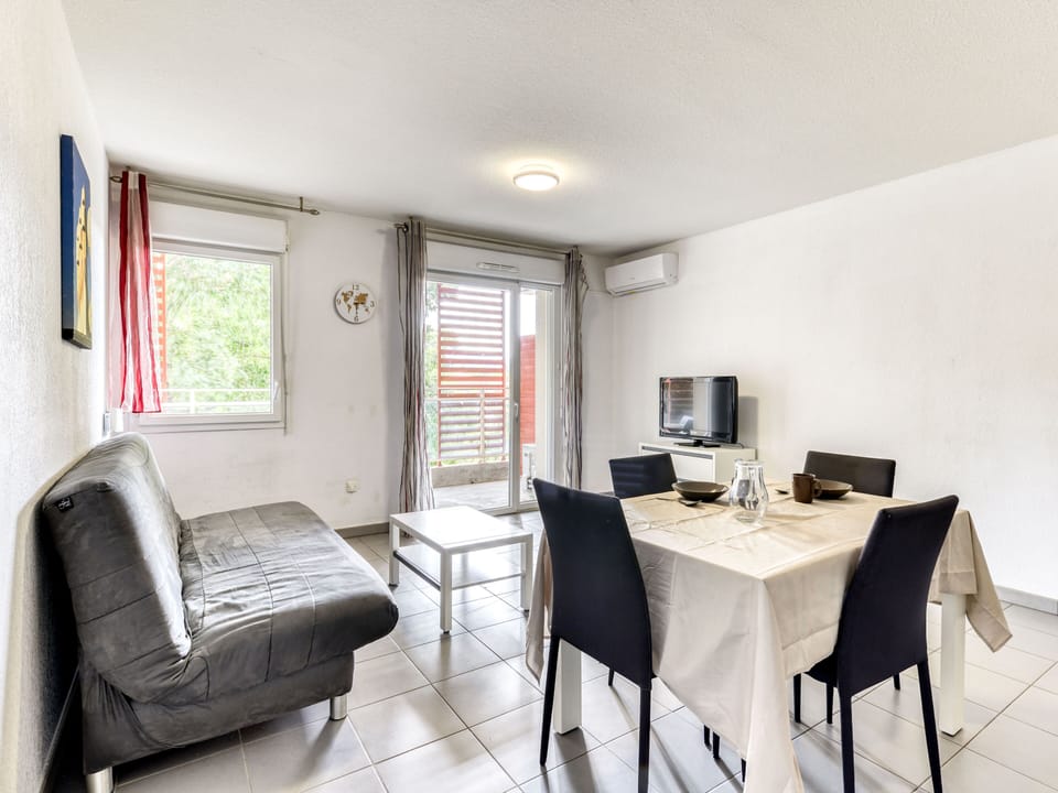Settle into the living area with a double sofa bed and flat-screen TV — the pool is just outside