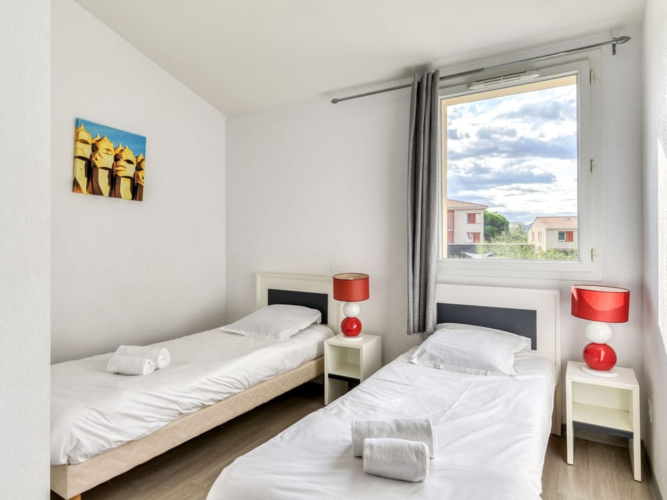 Upper-floor twin bedroom with colourful accents — works well for kids or two friends