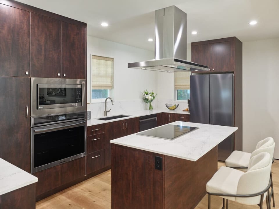 Modern kitchen with island seating and full appliances.