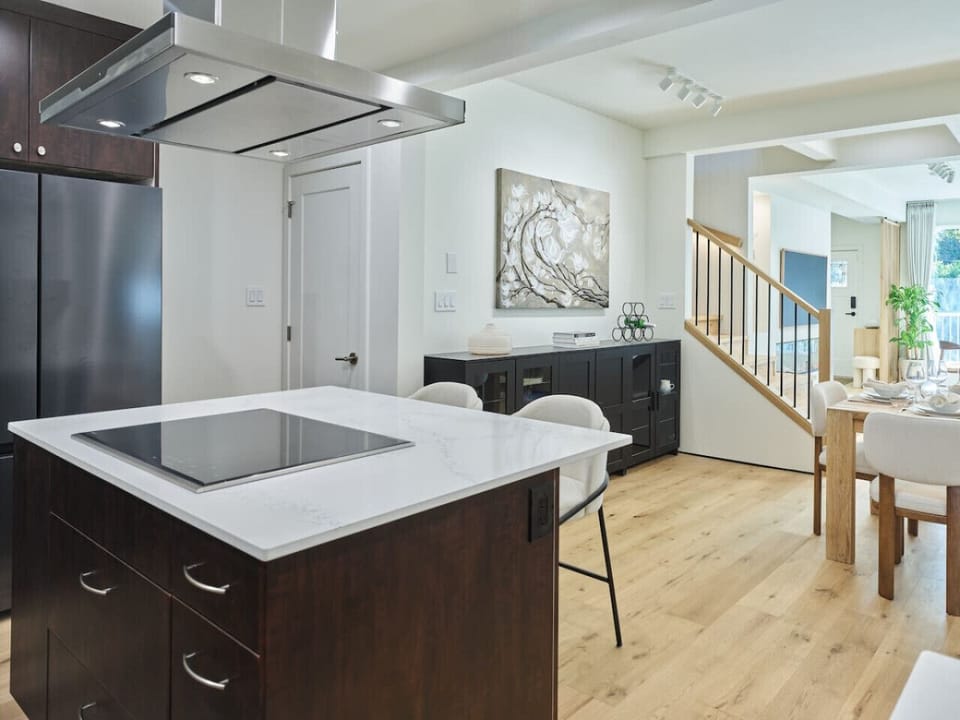 Modern kitchen with island seating and stainless appliances.