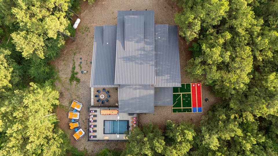 Birdseye view of the best amenities in Broken Bow - An outdoor movie theater, fire pit, heated pool with luxury seating, outdoor bowling and mini golf