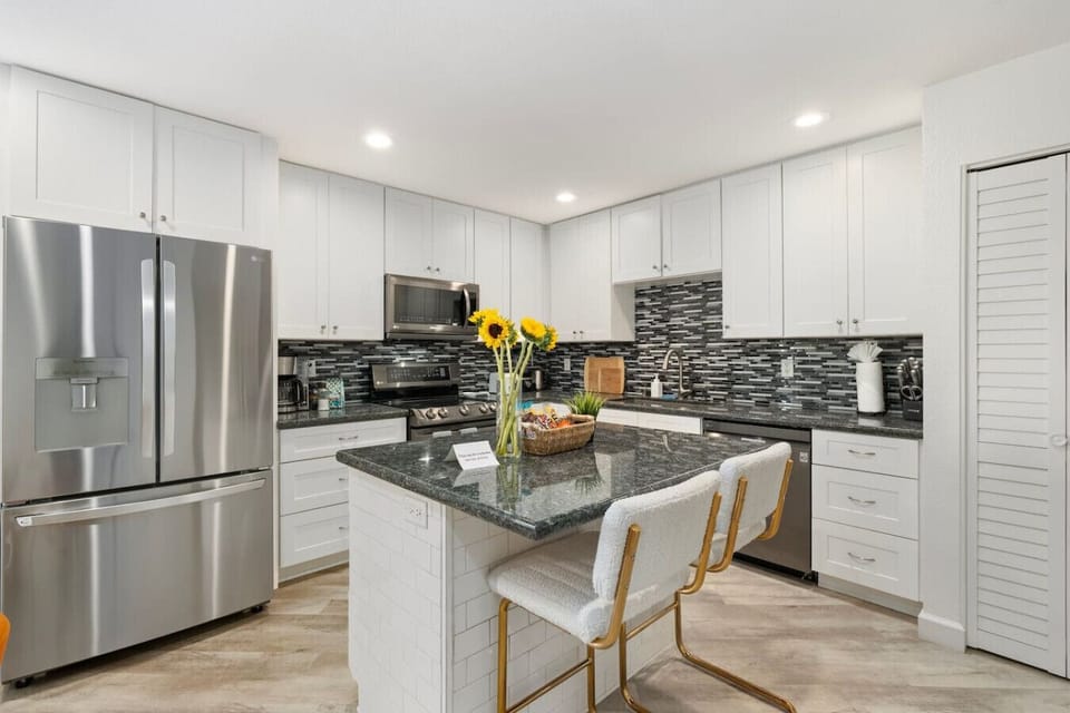 Fully equipped kitchen with a spacious island and two cozy bar stools—perfect for cooking, dining, and gathering.